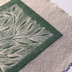 focus dans la carte imprimée main verte sur papier artisanal
