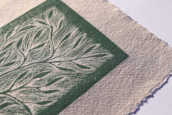 focus dans la carte imprimée main verte sur papier artisanal